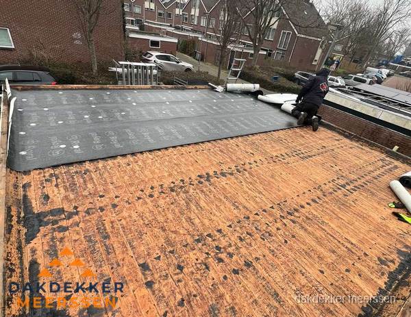 Dakdekker legt onderlaag op plat dak met houten constructie in Meerssen Dakdekker legt onderlaag op plat dak met houten constructie in Meerssen