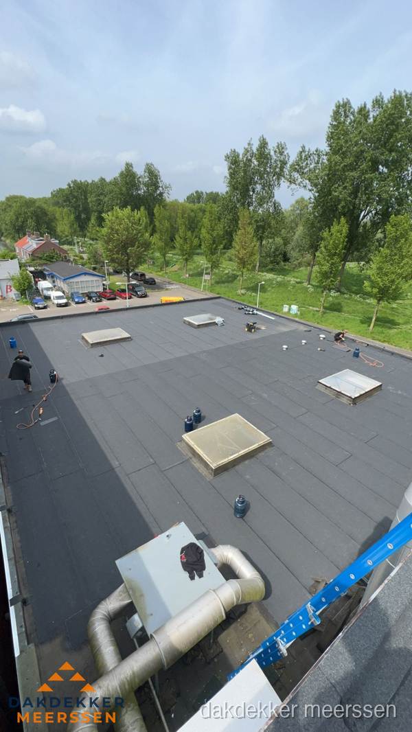 Dakdekker aan het werk op groot plat dak met bitumen in Meerssen Dakdekker aan het werk op groot plat dak met bitumen in Meerssen